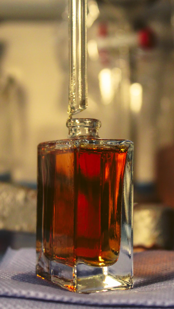 Frasco de perfume âmbar sob luz dourada